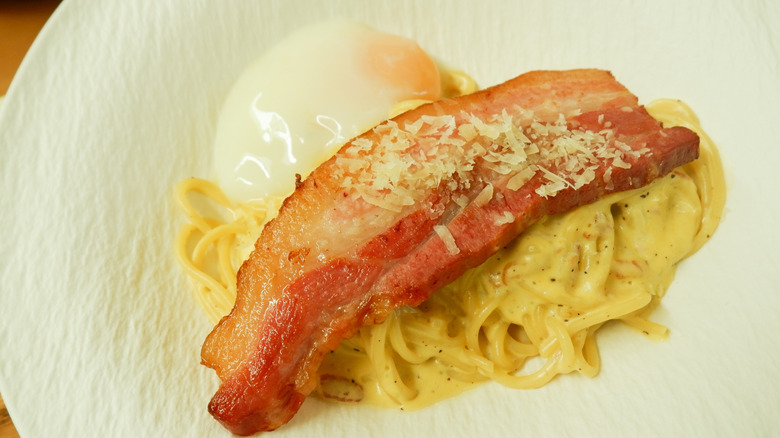 Carbonara topped with bacon and egg