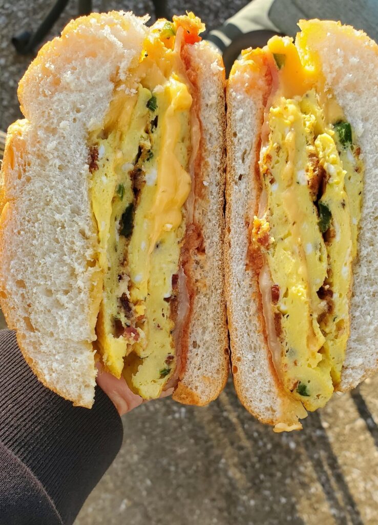 3 egg bacon omelette cheese sandwich with jalapeños and drizzle of hot honey.