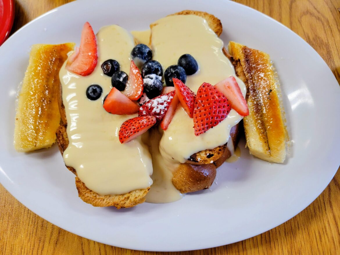A fruity French toast breakfast with vanilla icing and caramelized bananas.