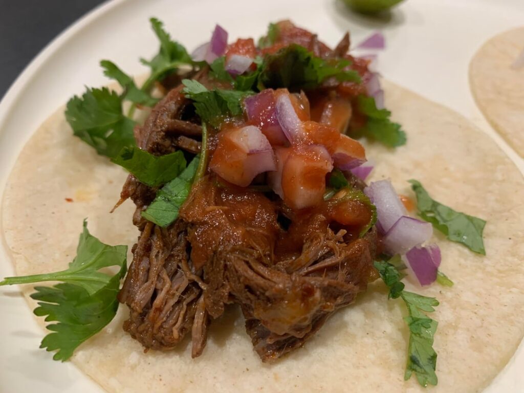 Tacos de barbacoa y consume