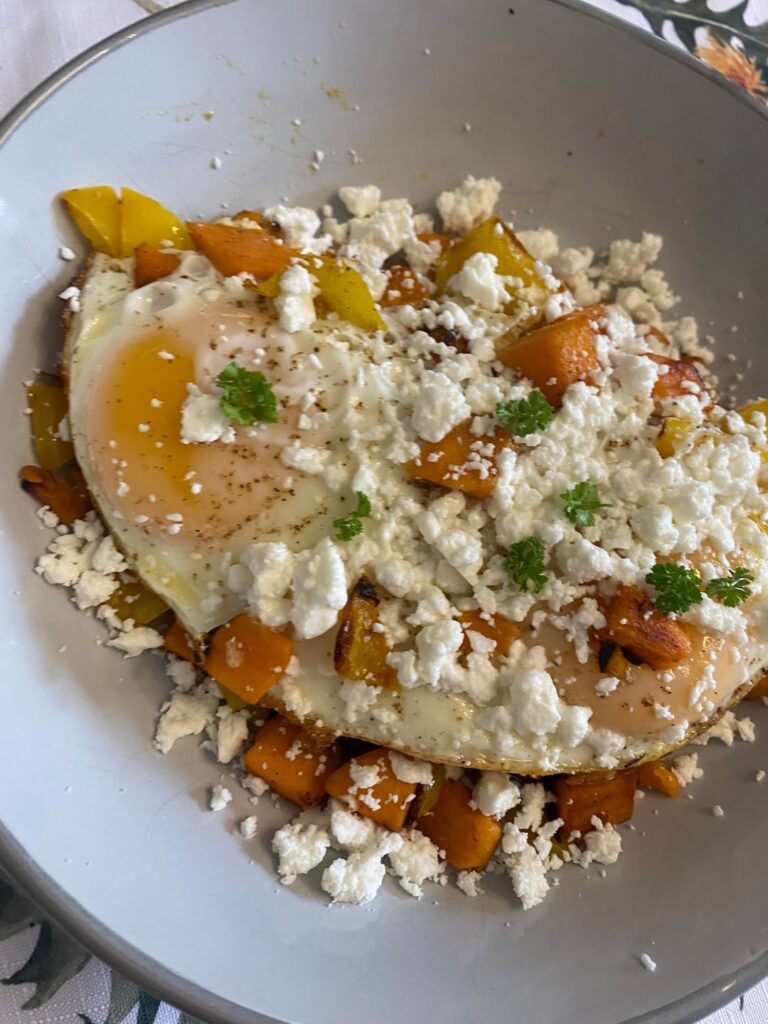 Fried eggs over sweet potato hash finished with feta and parsley