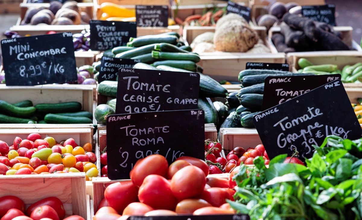 Provence market stall displaying fresh organic vegetables with prices