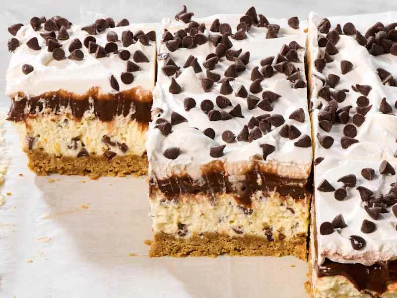 Layered dessert with a graham cracker crust, chocolate pudding, cream cheese filling, whipped topping, and chocolate chips.