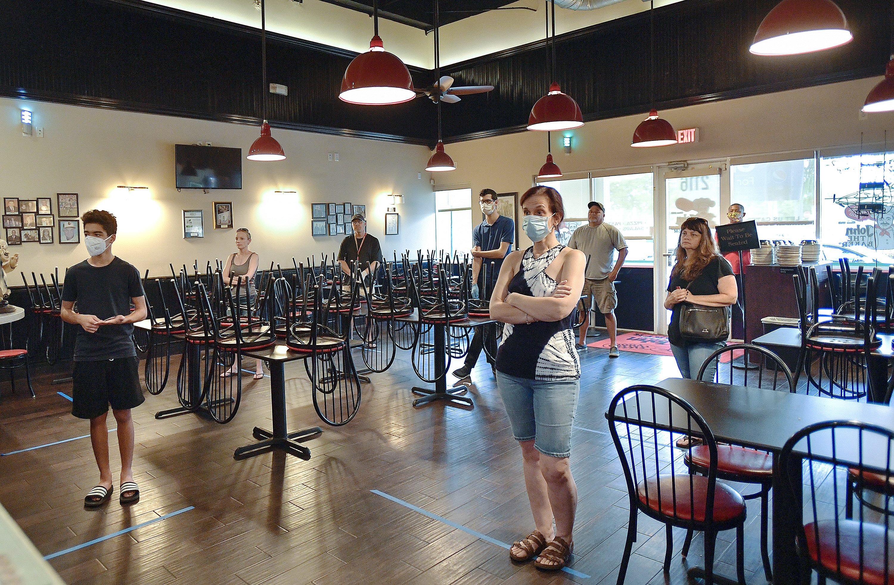 Customers wait to pick up pizzas at John the Baker in Pembroke Pines.