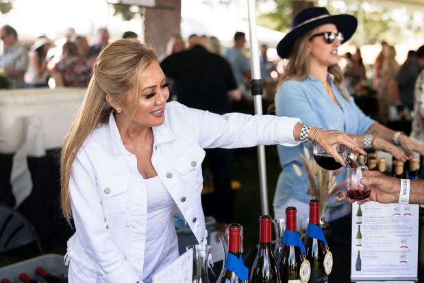 Mary Maitland with Domaine Della pours wine for a guest at The North Coast Wine & Food Festival at Luther Burbank Center for the Arts. (Loren Hansen / For The Press Democrat)