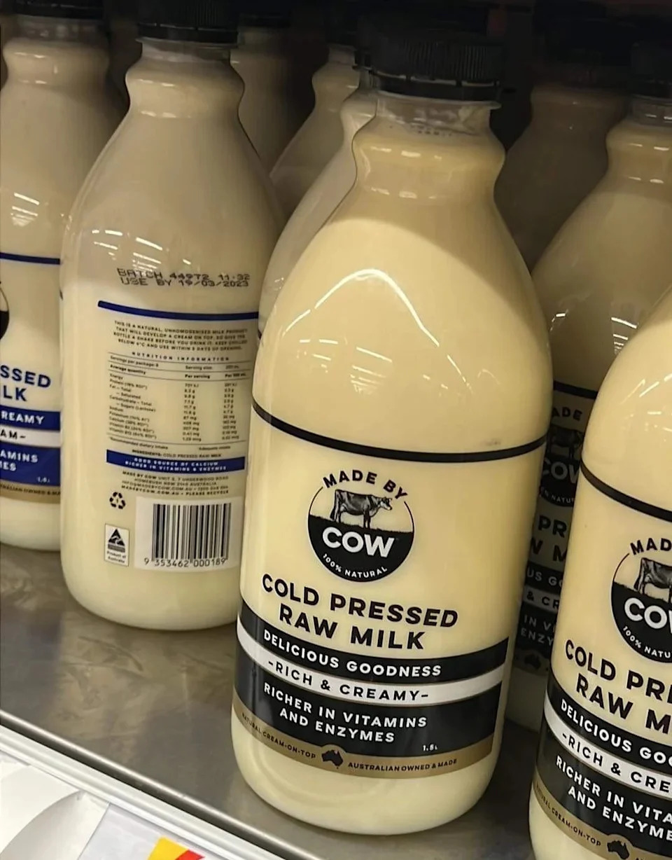 Bottles of "Made by Cow" cold-pressed raw milk on a store shelf