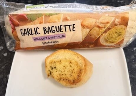 Sainsbury's garlic baguette packet with slice on kitchen counter