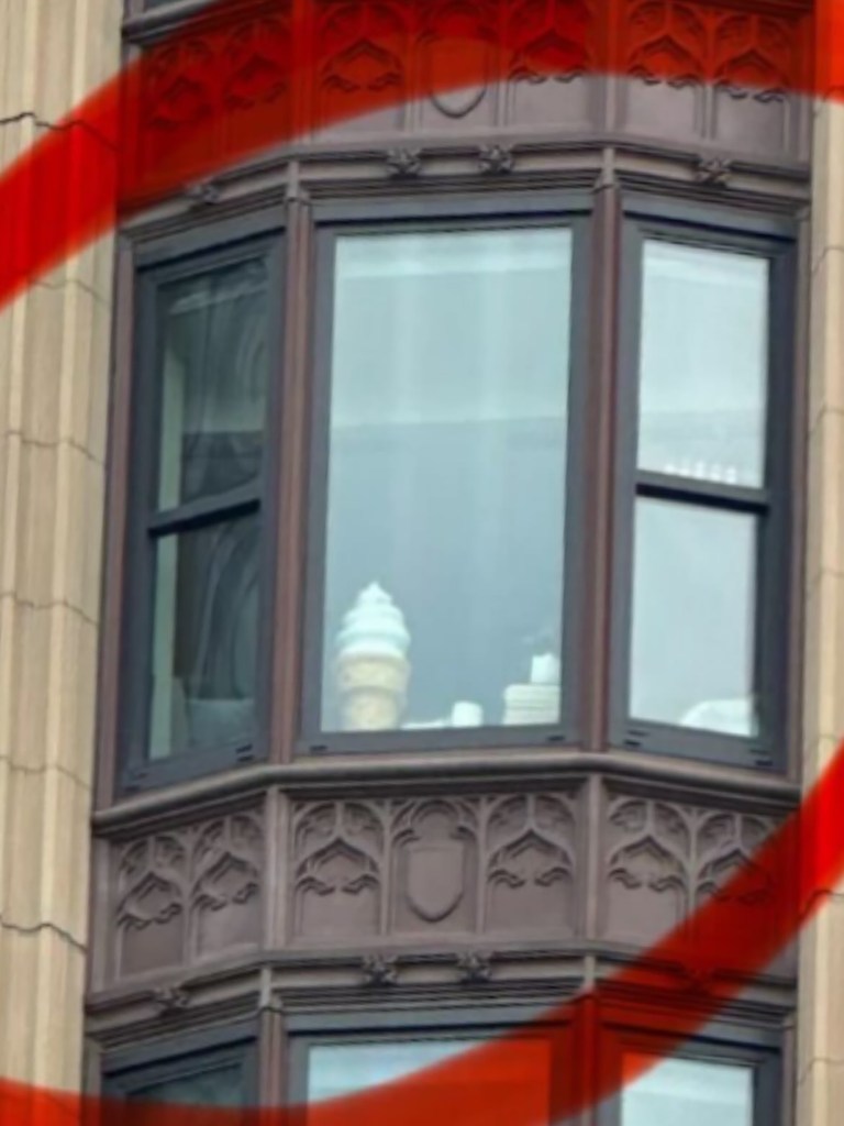 A bakery employee photo of what looks like Swirly the Flour Bakery mascot in an Emerson College dorm window
