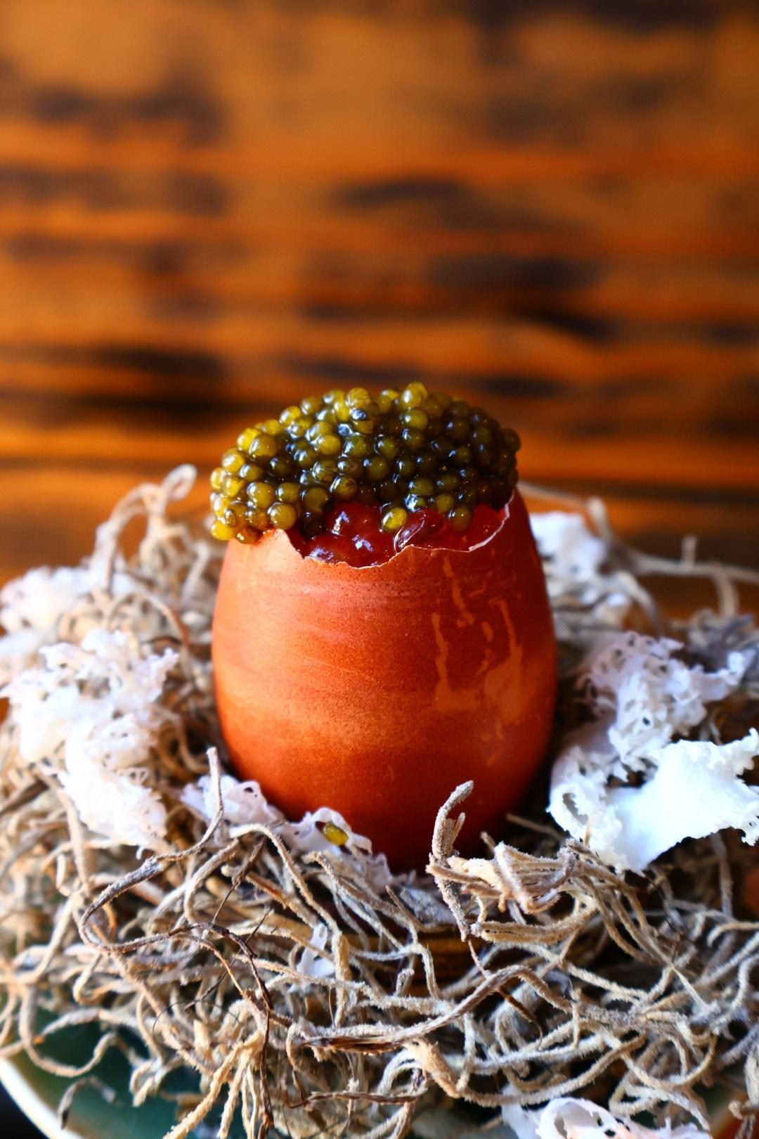 An egg in a shell topped with caviar.