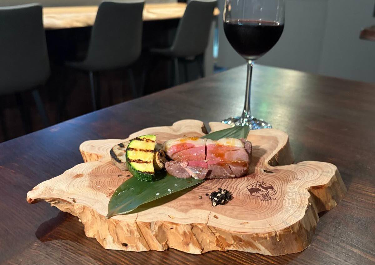 Wild boar served in a natural wood dish with red wine