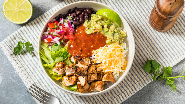 A homemade burrito bowl with rice, chicken, beans, and salsa