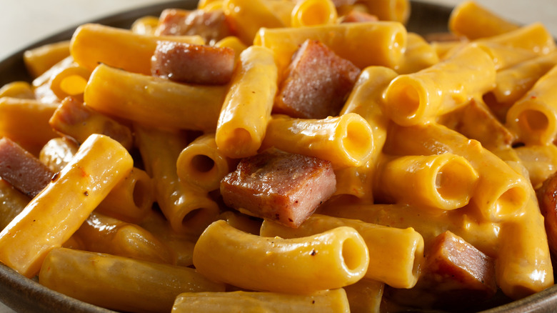 A bowl of macaroni and cheese with chunks of Spam