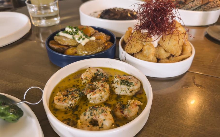 Prawns in olive oil are served in a white bowl.