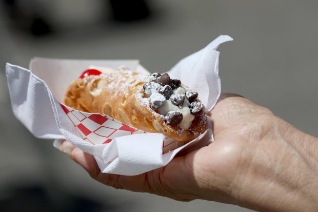 A festival-goer holds a cannoli, an Italian pastry with a sweet, creamy filling, during the Italian Family Festa at History Park in San Jose, Calif., on Saturday, Aug. 24, 2019. The 39th annual weekend festival that celebrates Italian culture is sponsored by the Italian American Heritage Foundation. (Anda Chu/Bay Area News Group)
