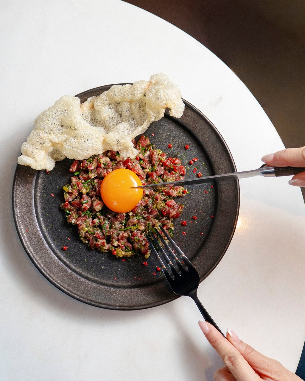 Sichuan beef tartare with a confit egg yolk and beef tendon crackers at Marrow. Photo: courtesy Marrow