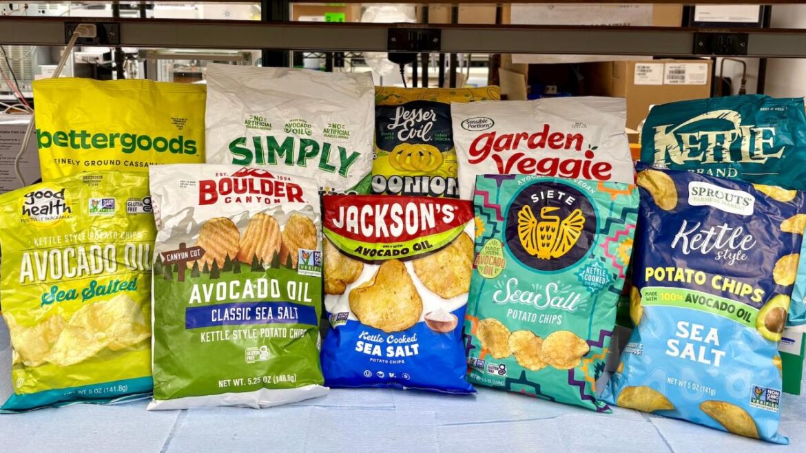 Assorted colorful chip and snack bags that claim they are made with avocado oil are lined on a table inside a lab. These chips were among the 54 avocado-labeled products tested in the Wang lab at UC Davis. (Selina Wang / UC Davis)