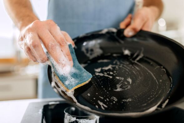 Close up shot of man washing cooking pan Close up shot of man washing cooking pan