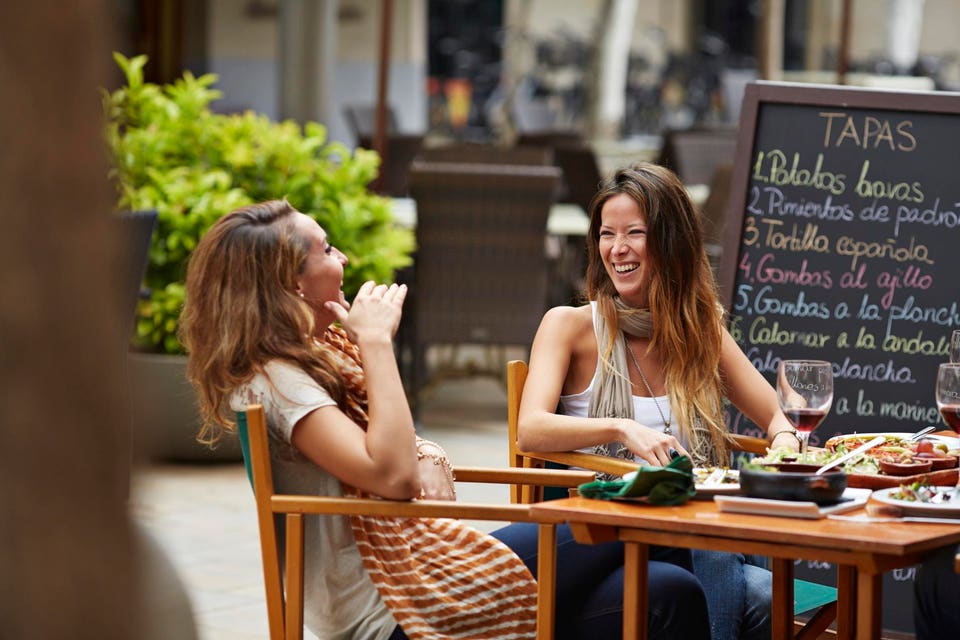 Two girls laughing together at restaurant