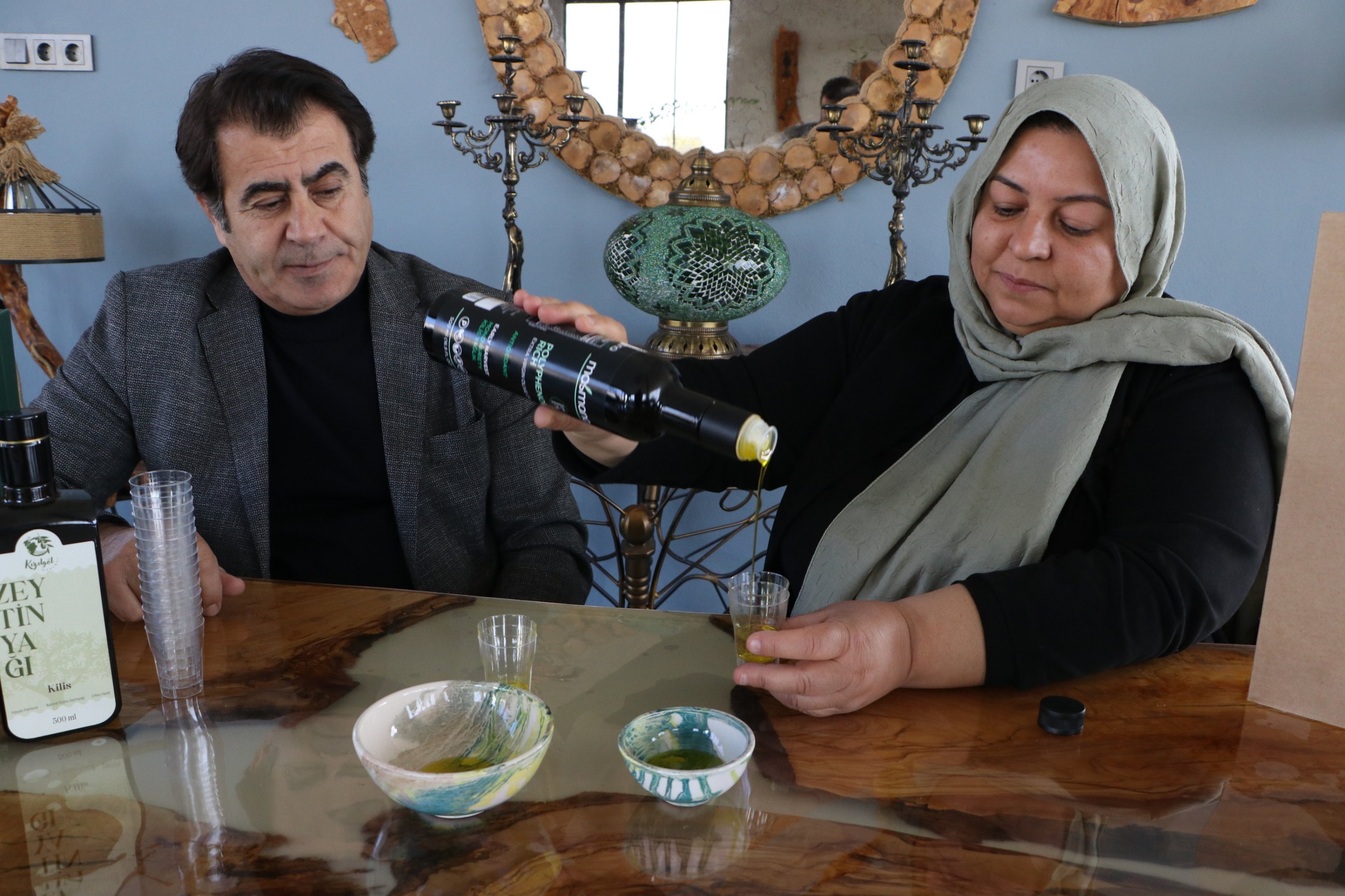 Ali Hayta (L) and Ayşegül Hayta display their Kilis olive oil, Kilis, southeastern Türkiye, March 5, 2026. (AA Photo)