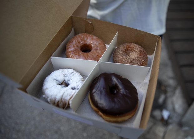 A customer holds vegan donuts from Beacon Doughnuts, Aug. 16, 2020. (Erin Hooley/Chicago Tribune)