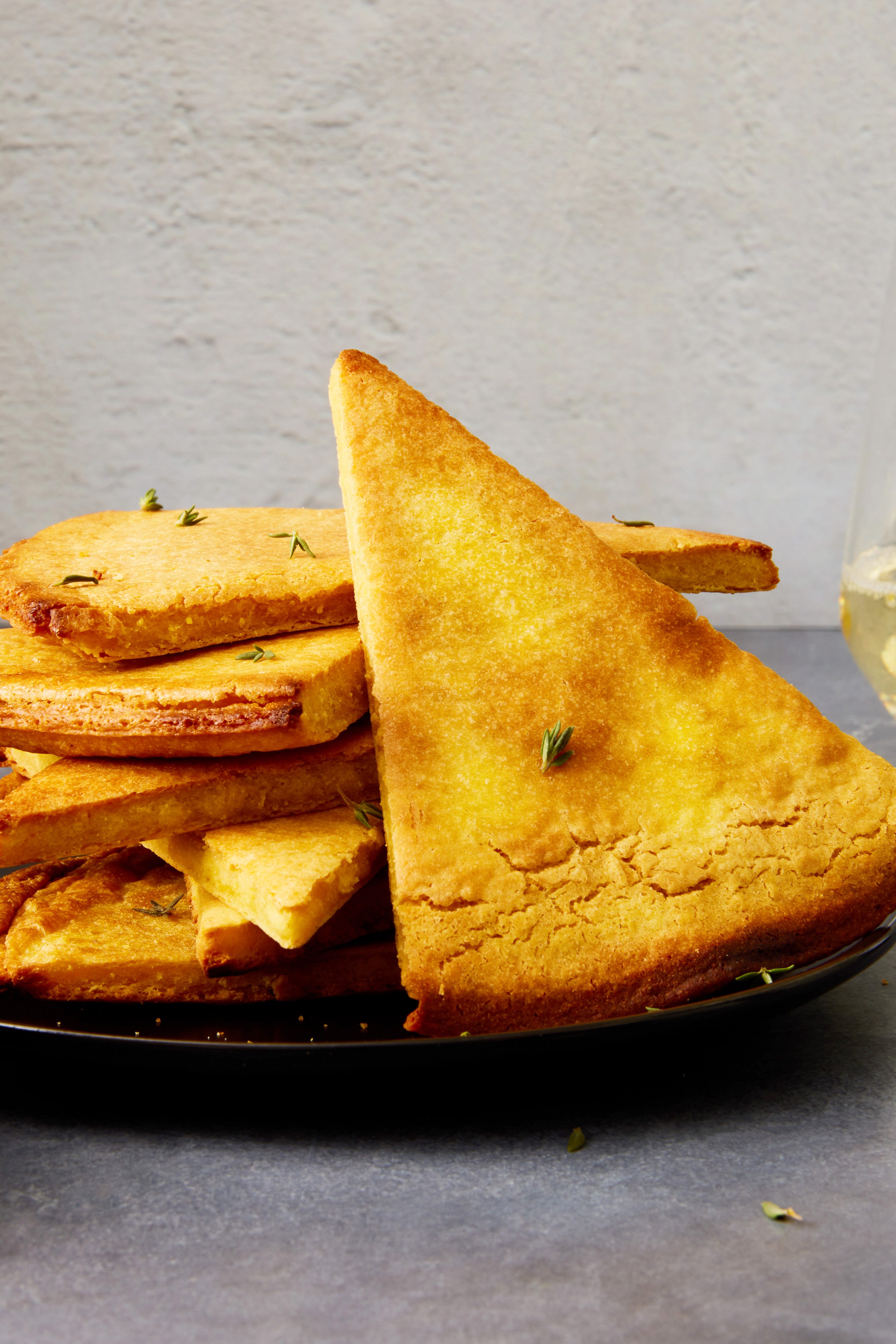 a golden brown mediterranean chickpea flatbread in a cast iron skillet with crispy edges and fresh herbs sprinkled on top